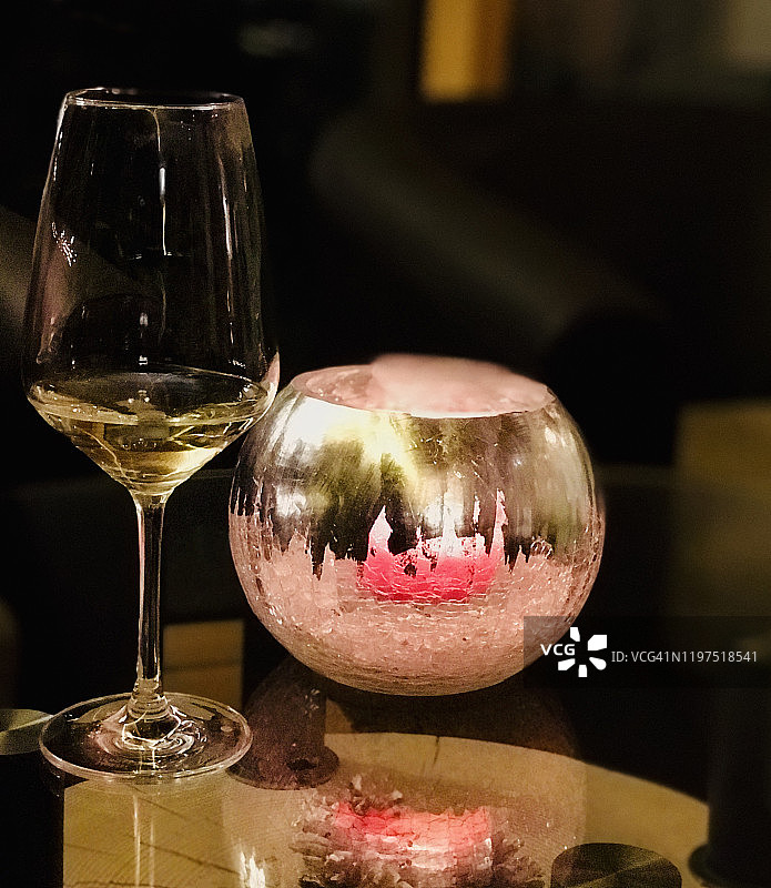 白色葡萄酒杯旁的优雅烛台。 静物图片素材