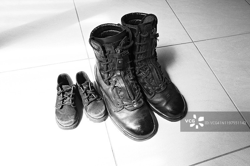 家庭日常：瓷砖上的黑色靴子图片素材