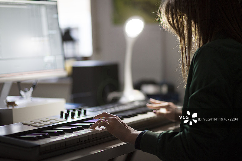 青少年用电脑音乐程序在电子键盘上练习钢琴图片素材