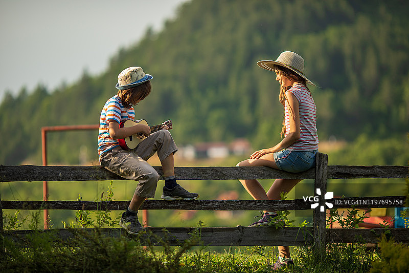 男孩和女孩在乡村欣赏音乐图片素材