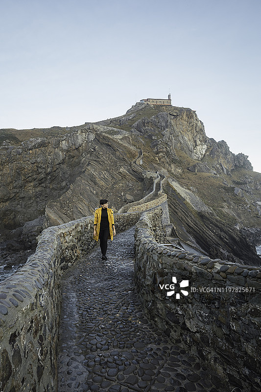 独自旅行的女人在远处走在圣胡安·德加兹特鲁加特图片素材