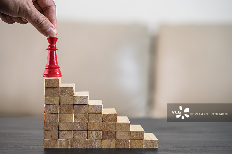 商业目标概念，商业战略战术概念，国际象棋概念，商人堆叠木块图片素材