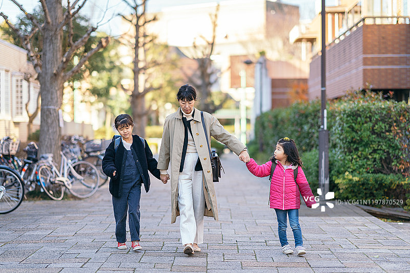 职场妈妈和女儿们在街上行走图片素材