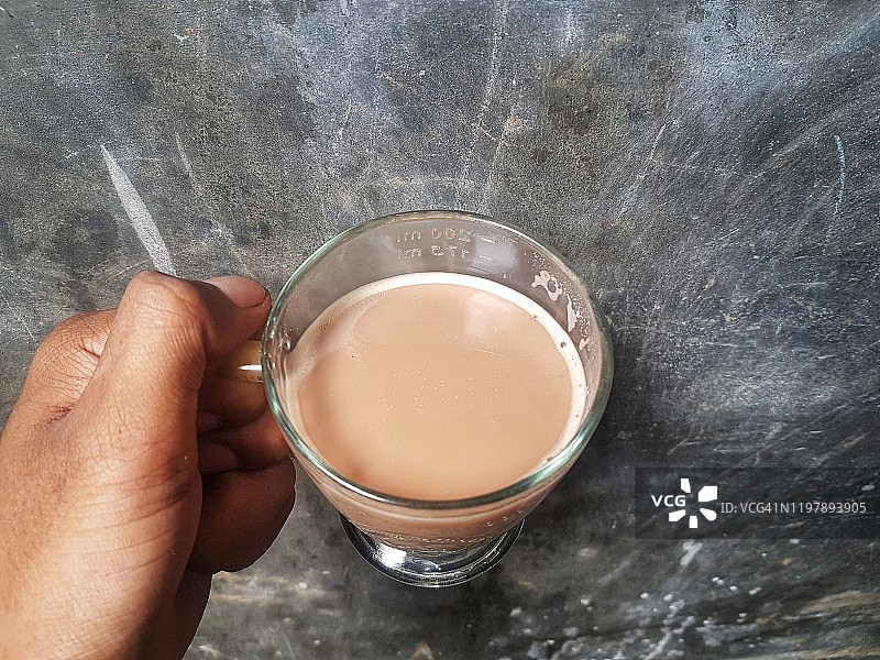 男人手拿巧克力奶站在水泥背景前图片素材