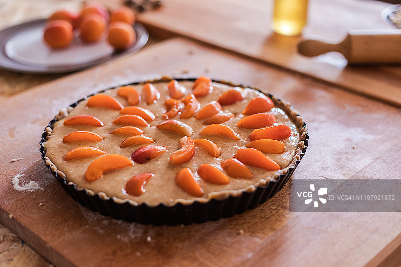 杏仁奶油馅饼的制作，模具中带有新鲜水果的生面团图片素材