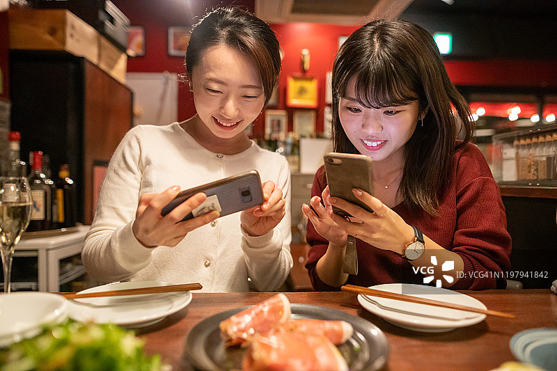 年轻女人用餐前拍摄美食图片素材