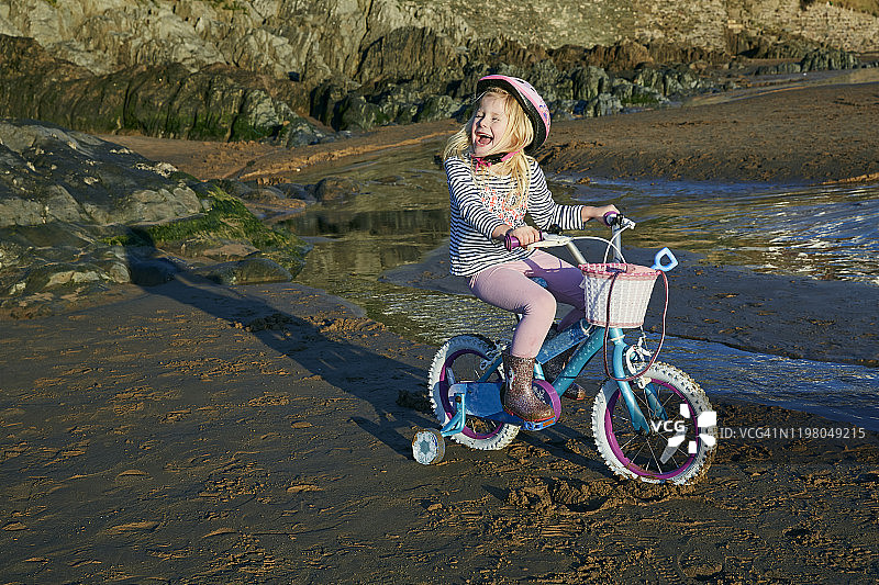 在伍拉科姆海滩骑自行车的女孩（4-5岁）图片素材