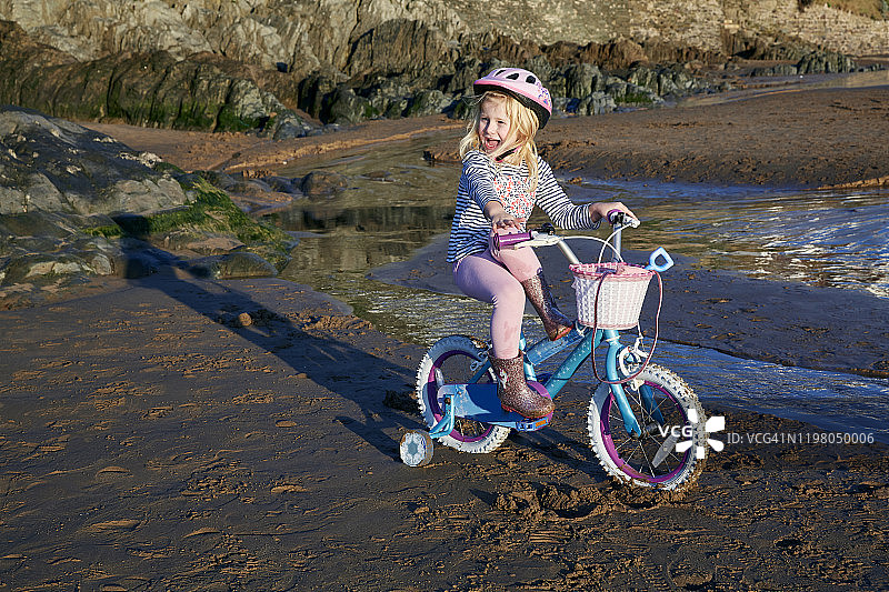 在伍拉科姆海滩骑自行车的女孩（4-5岁）图片素材