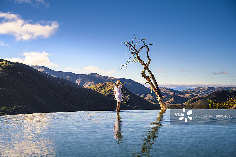 女子走在墨西哥瓦哈卡州 Hierve el Agua 的无边泳池上图片素材