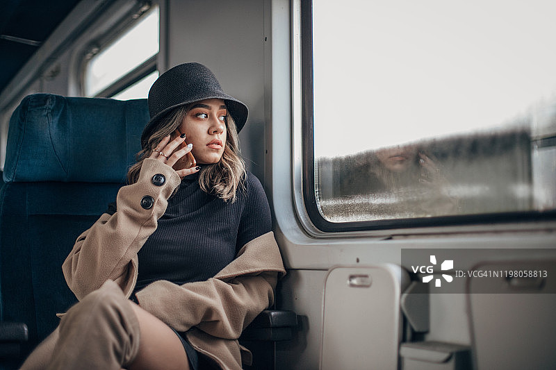 正在用手机交谈的优雅年轻女子图片素材