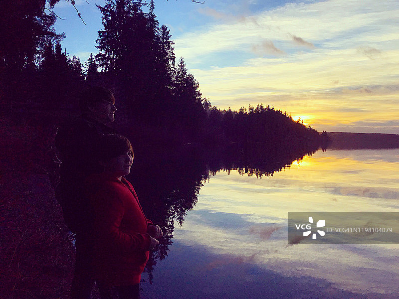 父子在奎纳尔特湖边看日落图片素材