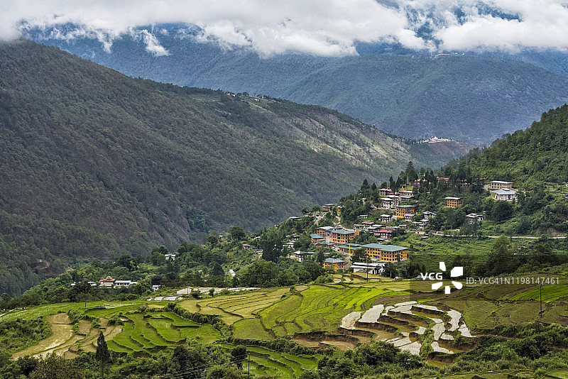 不丹普纳卡喜马拉雅山上的村庄房屋和稻田图片素材