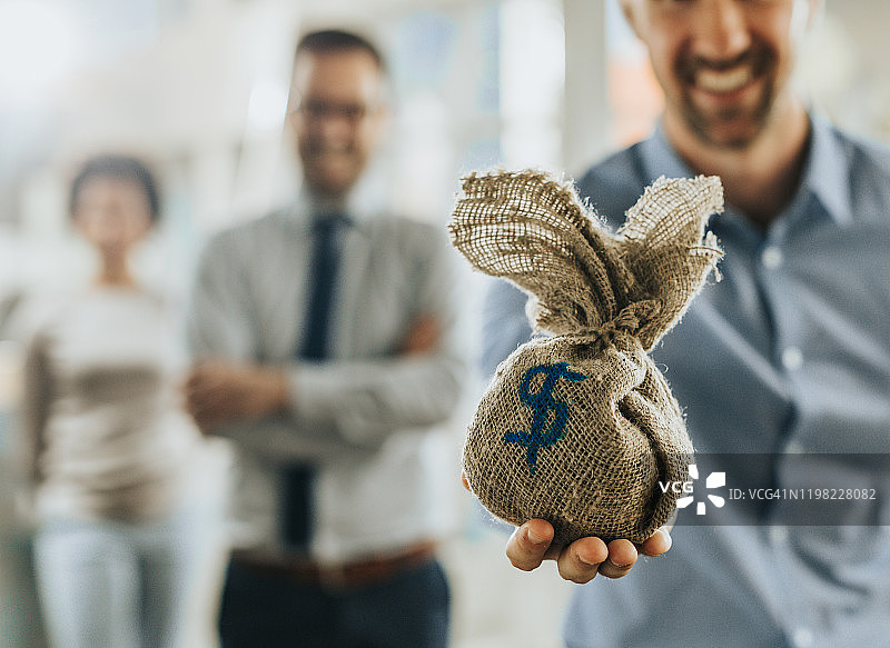 商务男人手提钱袋特写图片素材