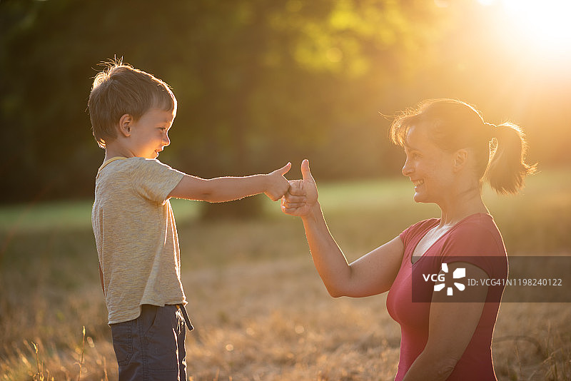 快乐的母亲和孩子互相竖起大拇指图片素材