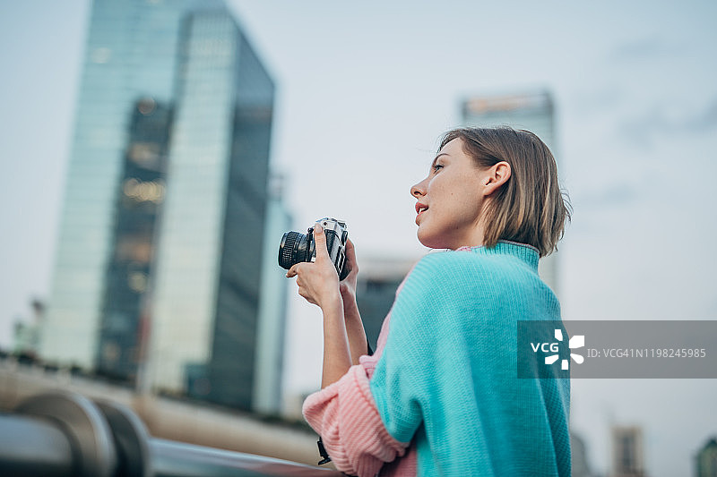 在城市里手持相机的女士图片素材