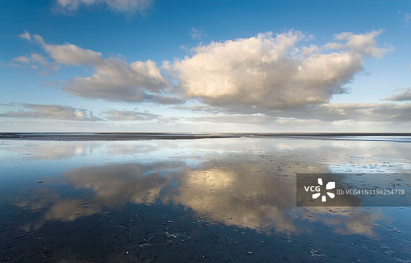 湿沙滩上的云彩倒影图片素材