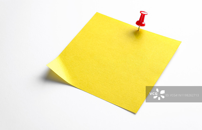 白色背景上的黄色便签纸，用于提醒信息，用纸夹固定，留有文字空间图片素材