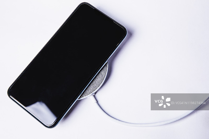 使用无线充电设备为手机电池充电图片素材