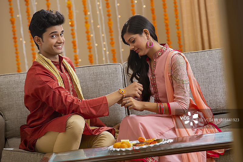 美丽的姐姐给兄弟系吉祥绳图片素材