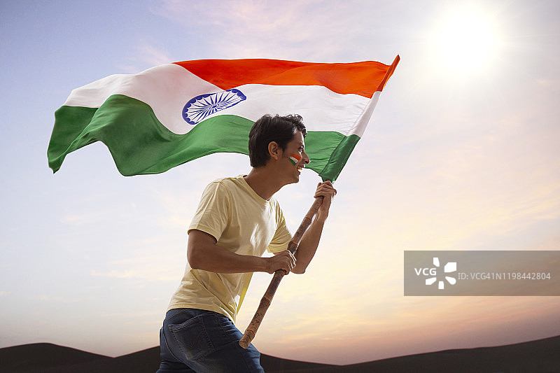 兴奋地挥舞着印度国旗奔跑庆祝独立日的年轻男人图片素材