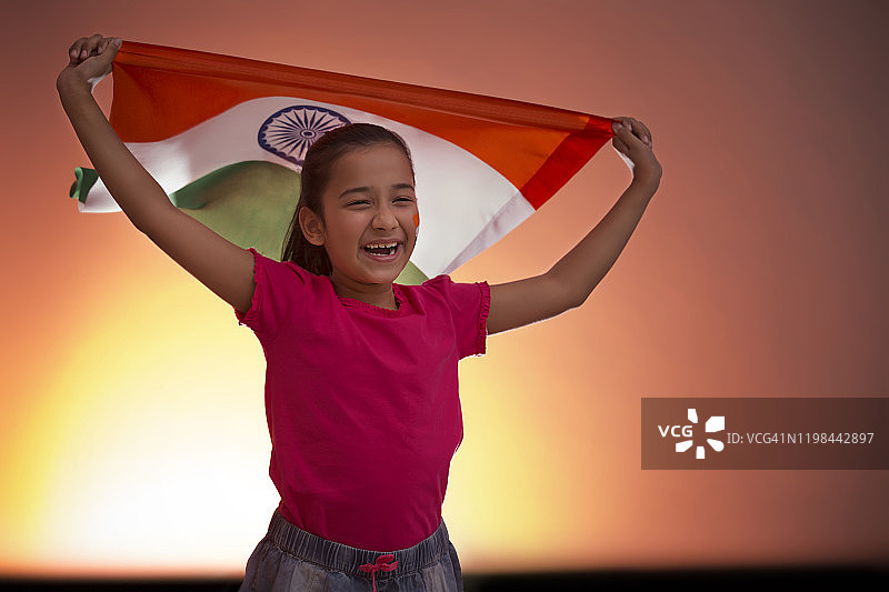 举着旗帜微笑的年轻女孩，独立日图片素材