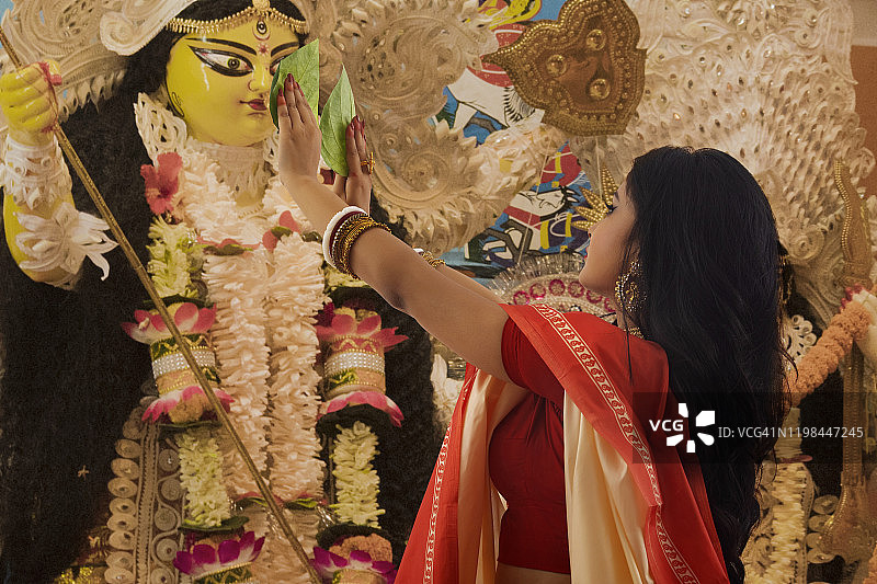 孟加拉已婚妇女用槟榔叶崇拜杜尔迦女神图片素材