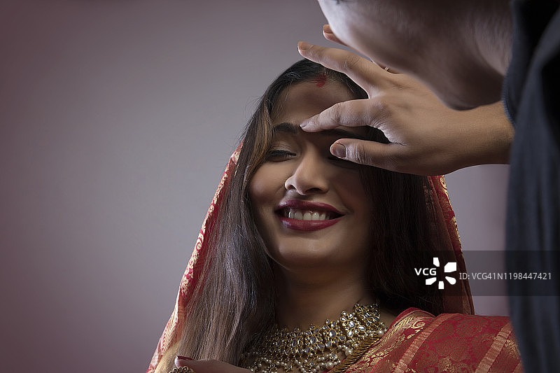 孟加拉男人在妻子的额头上点朱砂图片素材