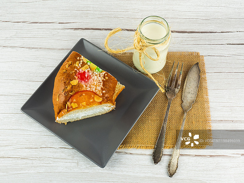 西班牙特色美食：奶油主显节蛋糕与牛奶，餐具置于粗麻布上图片素材