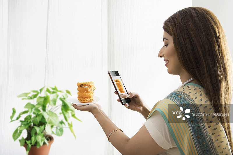 女人拍摄手中的甜点图片素材