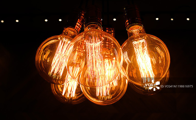 深色背景上的复古爱迪生玻璃灯，特写。室内设计师灯具和照明，选择性聚焦。图片素材