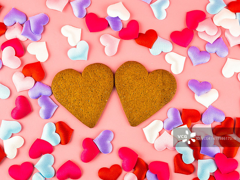 两块心形姜饼和许多彩色的心。爱与浪漫的概念图片素材