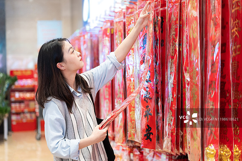 亚洲女性挑选色彩鲜艳的中国新年装饰品图片素材
