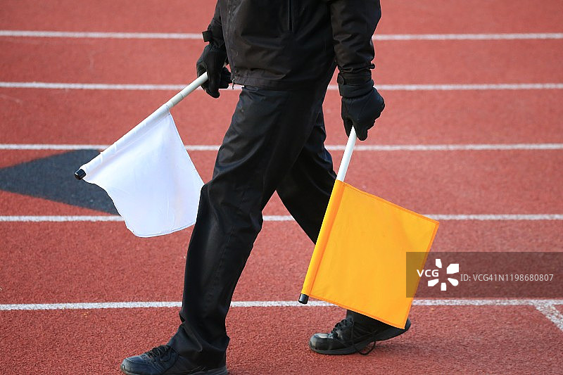 田径裁判员手持信号旗走在赛道上图片素材