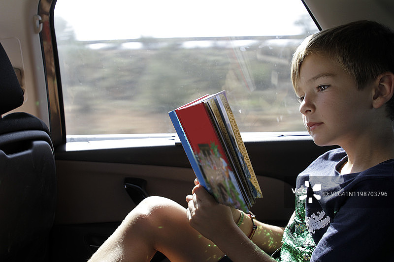 男孩在车里读书图片素材
