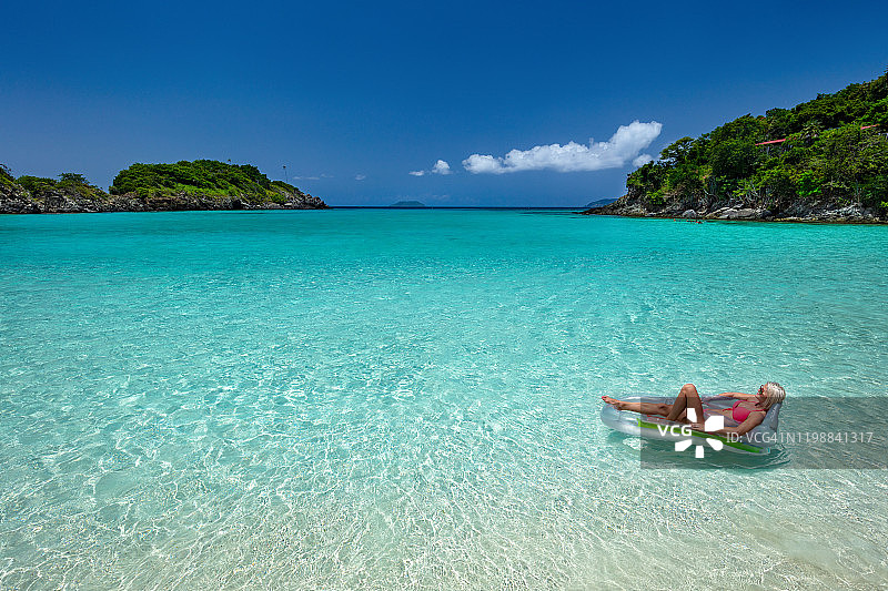 在加勒比海滩的木筏上放松的女人图片素材