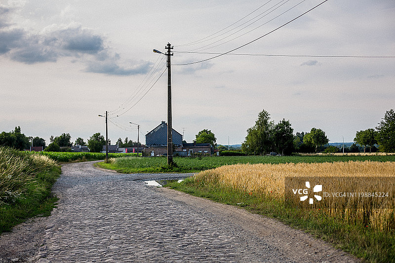 多云天空下田野中的空旷道路景色图片素材