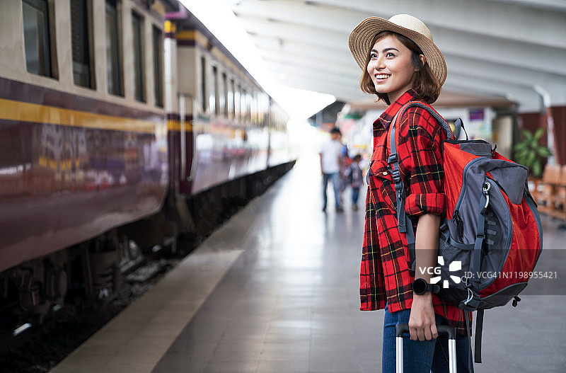 在火车站背着背包的年轻亚洲女性旅行者，旅行概念图片素材