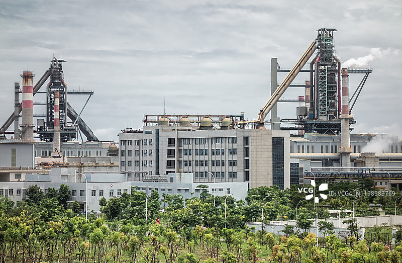 广东省湛江市的钢铁厂和绿色植物图片素材