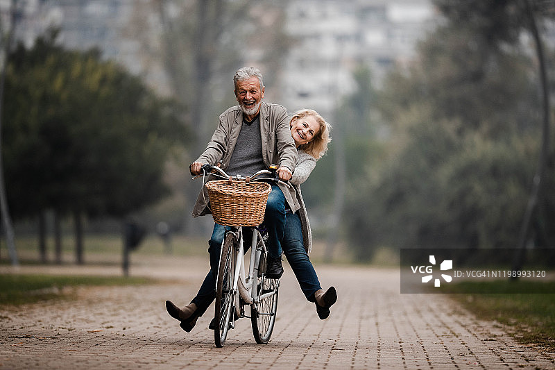 在秋日骑自行车玩耍的老年夫妇图片素材