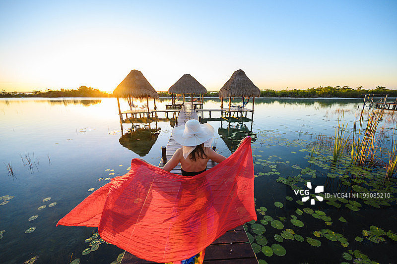 在墨西哥的码头上，女人玩着红色纱笼图片素材