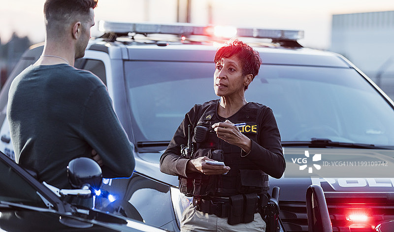 女警员向一名年轻男子录取口供图片素材
