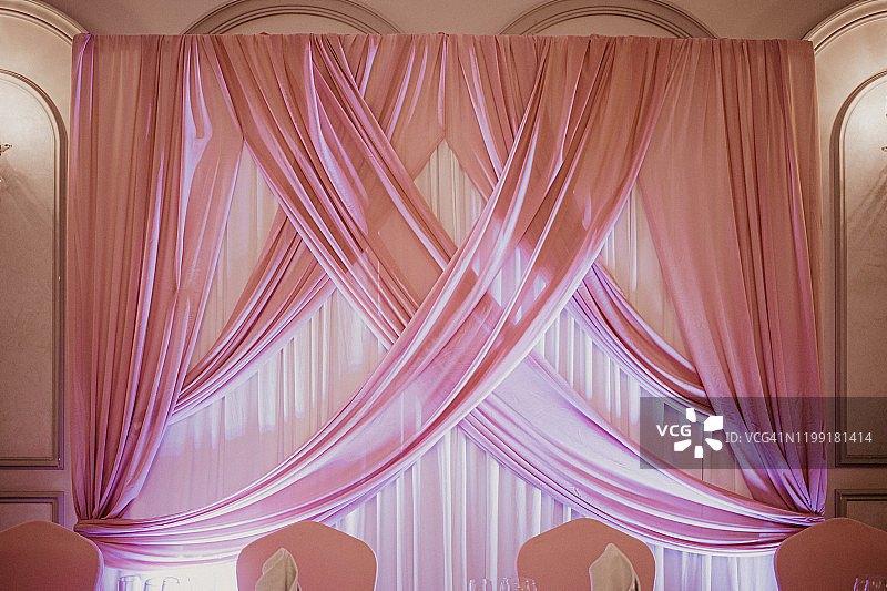 餐厅里的粉色婚礼装饰：新人桌上的粉色布艺墙图片素材