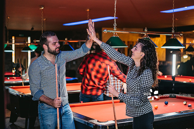 情侣斯诺克获胜后击掌庆祝图片素材