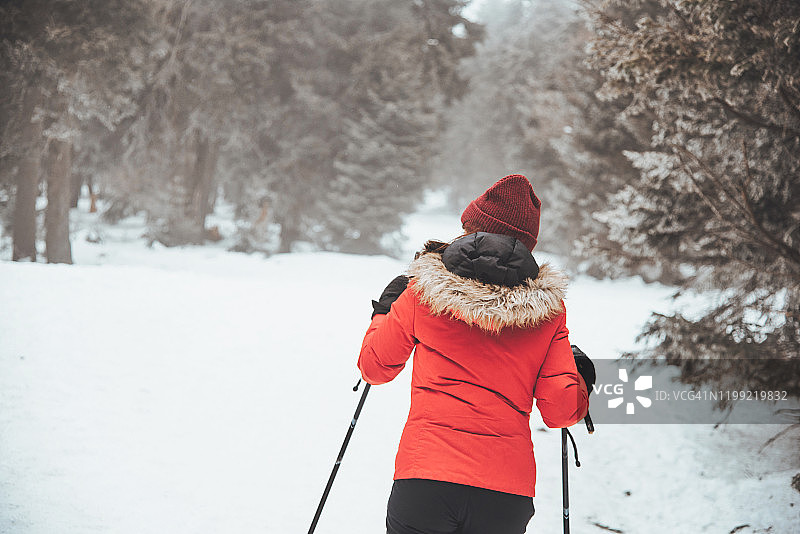 穿红色外套的少女越野滑雪图片素材