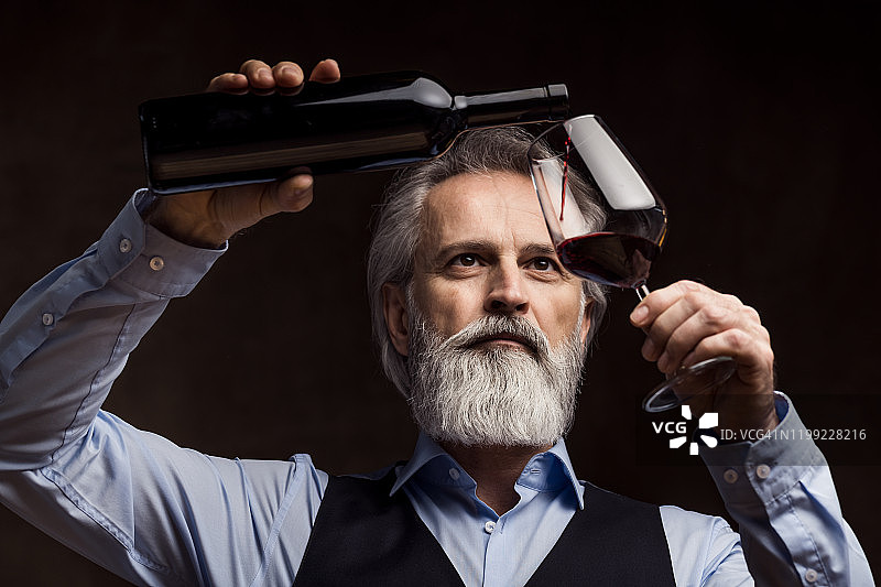 品尝红酒的老年侍酒师图片素材