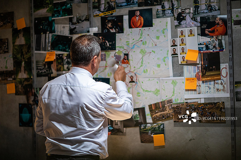 警察侦探用放大镜查看地图图片素材