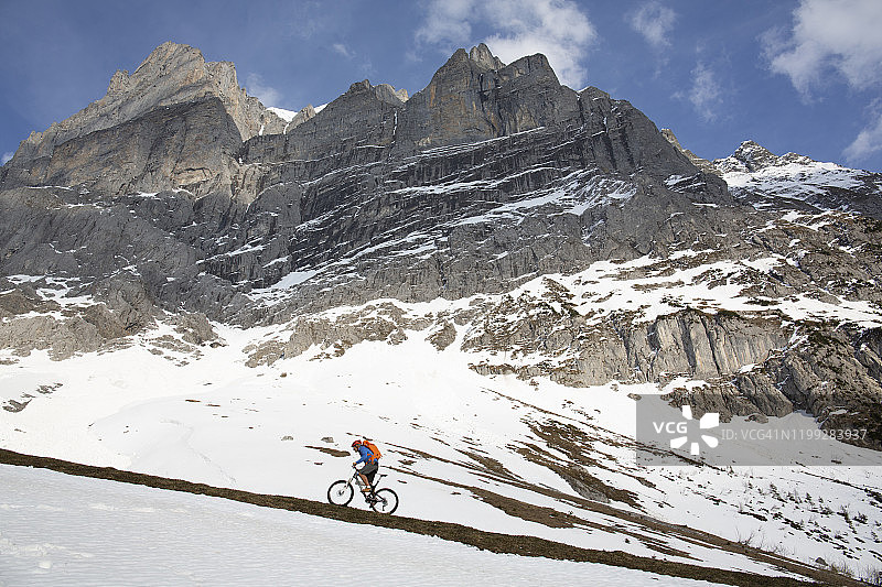 山地车手雪山坡道骑行图片素材