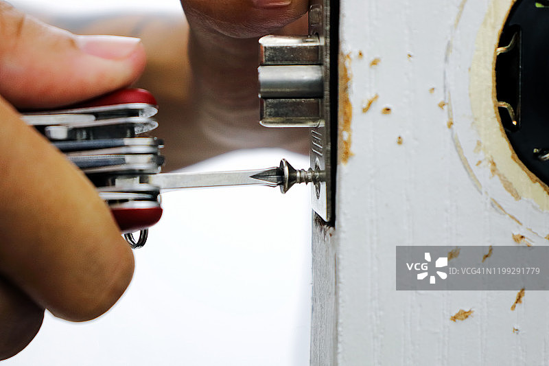 男子修理房间门锁，专业锁匠安装或修理新锁图片素材