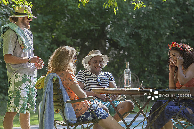 在游泳池边放松的年轻朋友图片素材