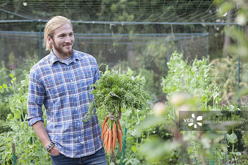 拿着胡萝卜的年轻男人图片素材